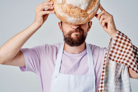 bearded man in white apron cooking foodの写真素材