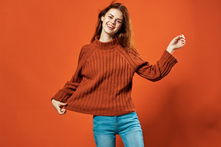 cheerful woman in red sweater posing fashion studio isolated backgroundの写真素材