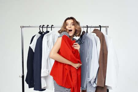 pretty woman trying on a red shirt studio emotionの写真素材