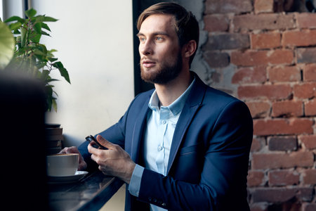 business man in a suit of a cafe official talking to the phoneの写真素材
