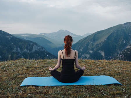 woman meditates in nature in the mountains of pacification freedomの写真素材