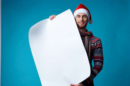 Cheerful man in a santa hat holding a banner holiday isolated backgroundの写真素材