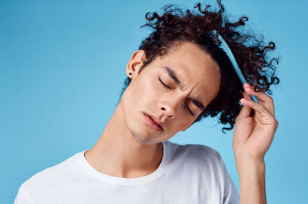 curly guy with a comb hair lifestyle blue backgroundの写真素材