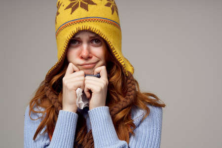 sick woman neck scarf with a hat on his head light background