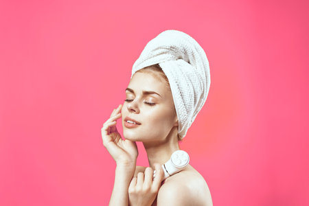 woman with bare shoulders and cosmetology clean skin relaxation pink backgroundの写真素材