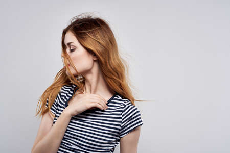 cheerful woman in a striped t-shirt gesture with his hands model studioの写真素材