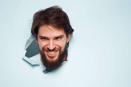 man in blue shirt breaks through the background fun isolated backgroundの写真素材