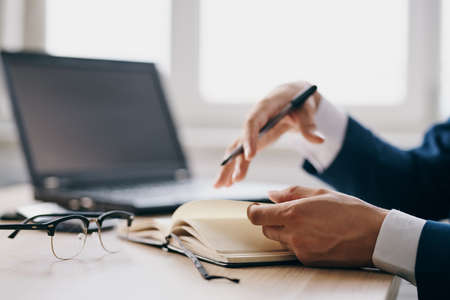 bearded man sitting at a desk in front of a laptop finance officialの写真素材