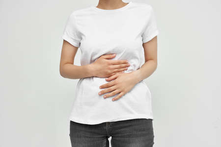 woman with abdominal pain diarrhea health problems light backgroundの写真素材