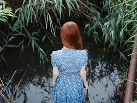 woman in blue dress green leaves nature posingの写真素材