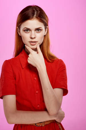 pretty woman in red dress hand gestures luxury pink backgroundの写真素材
