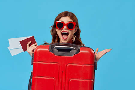 cheerful woman Tourist red suitcase passenger airport flight documentsの写真素材