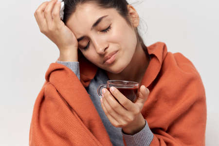 sick woman sitting at home on the couch cold treatment dissatisfaction