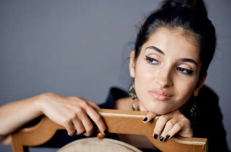 pretty woman in a black dress near the chair luxury fashion lifestyle studioの写真素材