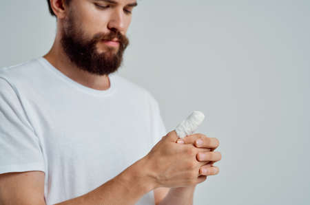 male patient bandaged hand injury to fingers isolated backgroundの写真素材