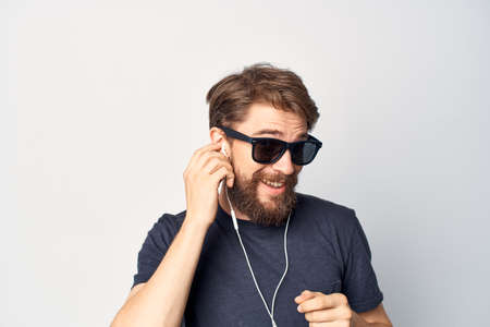 Cheerful man wearing glasses listening to music on headphones studio lifestyle