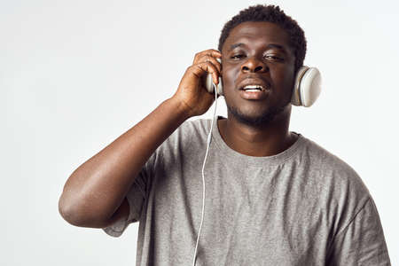 Cheerful man of African appearance in headphones listens to music