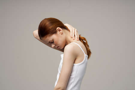woman rheumatism pain in the neck health problems light backgroundの写真素材