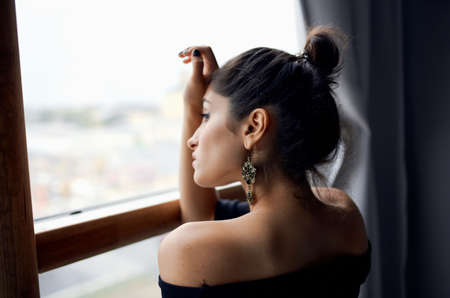 brunette near window posing attractive look earrings lifestyle studioの写真素材