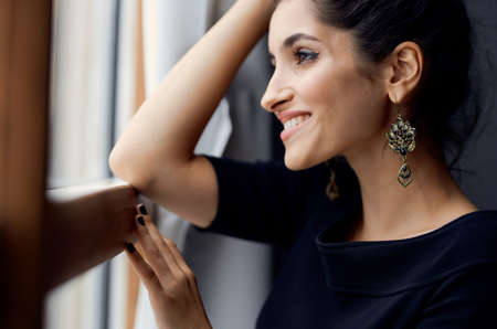 pretty woman holding a camera near the window decoration fashion elegant styleの写真素材