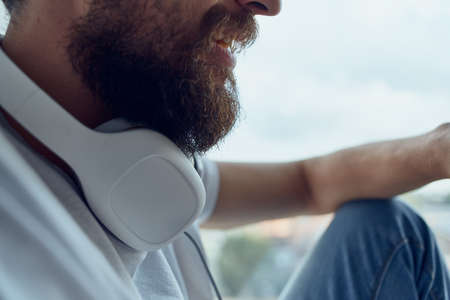 Man sitting near the window in headphones listening to music on headphonesの写真素材