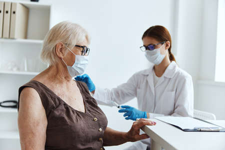 nurse in white coat makes an injection in the arm health careの写真素材