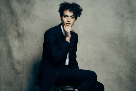 guy in black jacket sitting on the floor fashion elegant styleの写真素材