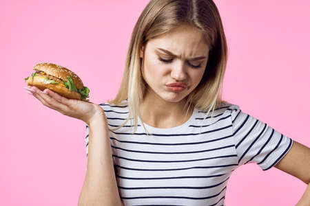 cheerful woman with fast food in her hands snacks delicious pink backgroundの写真素材