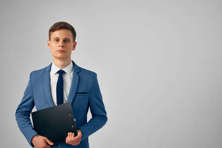 man in a suit with documents in his hands professional office light backgroundの写真素材