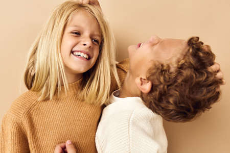 portrait of cute children hugs laughter friendship beige backgroundの写真素材