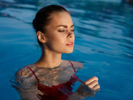 pretty woman swims in the pool and glamor luxury closeup cosmeticsの写真素材