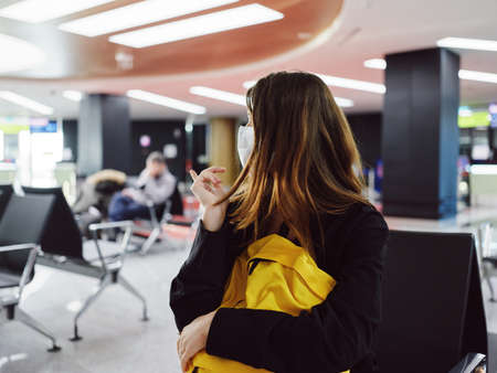 woman sitting at the airport looking to the side of the waiting passengerの写真素材