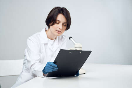 cheerful female laboratory assistant in white coat microscope professional science experimentsの写真素材