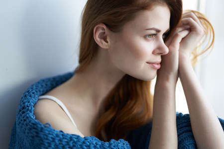 woman sitting on the windowsill with a blue plaid morningの写真素材