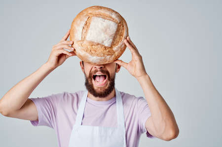 a man in a chefs uniform holding bread in his hands kitchen Professional industryの写真素材