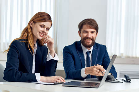 man and woman managers talking at the table in front of laptop team technologyの写真素材