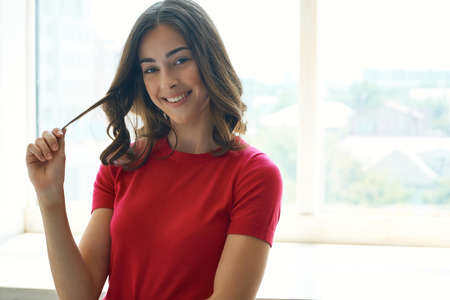 cheerful woman holding on to hair cosmetics isolated backgroundの写真素材