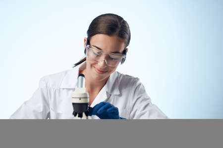 female laboratory assistant at work table microscope professionalの写真素材