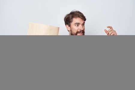 bearded man in a white t-shirt with a package in his hands emotions mockupの写真素材