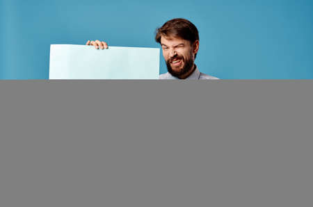 Cheerful man with blue mockup poster sign copy-space close-upの写真素材