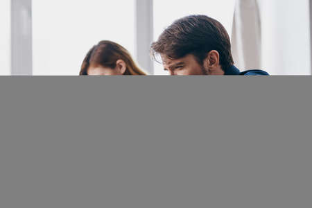 business man and woman sitting at a desk with a laptop communication finance professionalsの写真素材