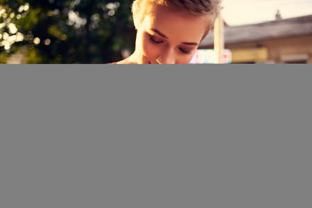 pretty woman with short hair eating ice cream on the streetの写真素材