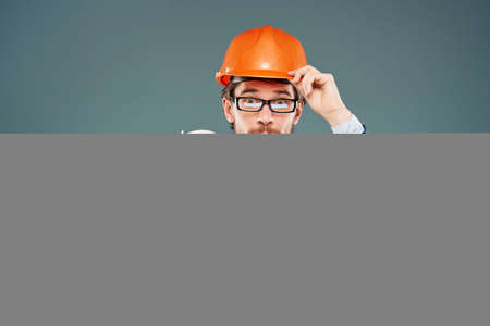 surprised man orange helmet on the head Studio hand gestureの写真素材