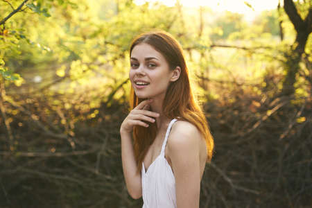 cheerful pretty woman in white dress nature trees summerの写真素材