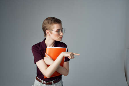 short haired woman with red folder in hands student learningの写真素材