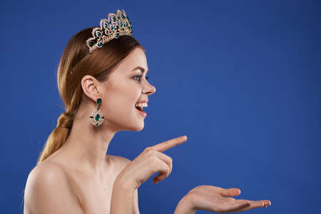 Princess with a crown on her head makeup model hand gesture isolated backgroundの写真素材