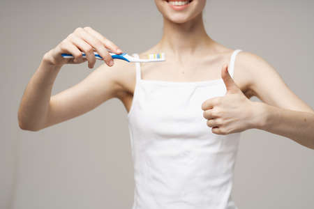 pretty woman with a toothbrush in hand morning hygiene isolated backgroundの写真素材