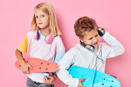 fashion kids skateboards headphones posing pink backgroundの写真素材