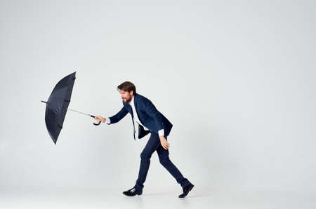 business man in suit umbrella rain protection elegant style light backgroundの写真素材