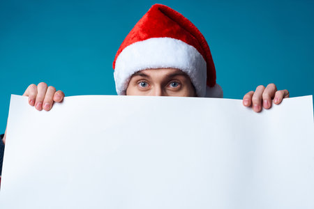 Cheerful man in a santa hat holding a banner holiday isolated backgroundの写真素材